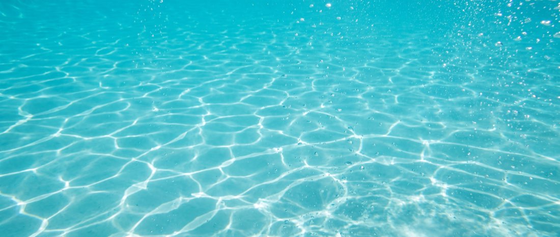 Eau de piscine cristalline traversée par la lumière